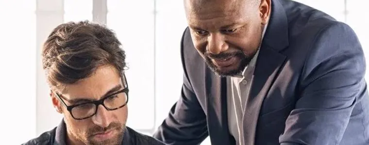 Management, gestion des conflits et des équipes : deux managers collaborent devant un ordinateur